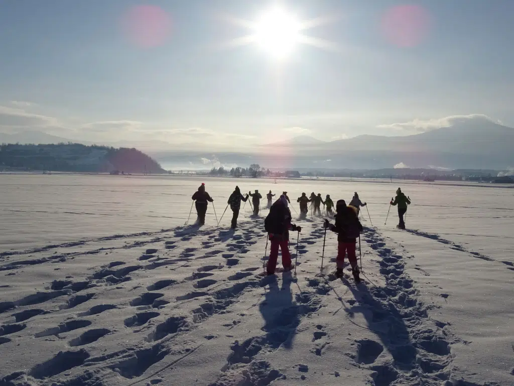 Ihr seht die Klasse einer Schule beim Schneeschuhwandern im Murtal im Winter. JUFA Hotels bietet erholsamen Familienurlaub und einen unvergesslichen Winterurlaub.