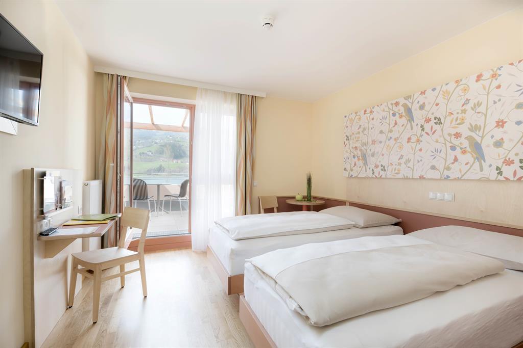 Ihr seht ein Familienzimmer mit Balkon im JUFA Hotel Stubenbergsee. Der Ort für erholsamen Familienurlaub und einen unvergesslichen Winter- und Wanderurlaub.